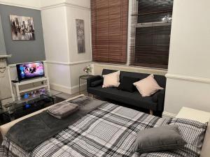 a living room with a bed and a couch at Norbury House - Apartment 1A in Norbury