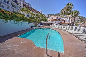 a swimming pool in front of a building with palm trees at Quiet Avalon Getaway Villa with Ocean View and Balcony in Avalon