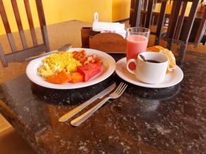 坎皮納的住宿－卡薩貝拉賓館，餐桌,带两盘食物和一杯咖啡的桌子