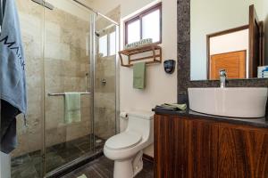 a bathroom with a toilet and a sink and a shower at Villa with ocean view, pool, restaurant and rooftop in Isla Mujeres +20 photos