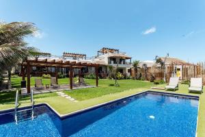 a villa with a swimming pool and a house at Villa with ocean view, pool, restaurant and rooftop in Isla Mujeres
