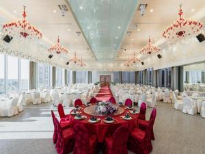 um grande salão de banquetes com mesas vermelhas e cadeiras brancas em Formosa Yacht Resort em Anping