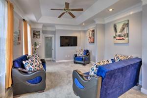 sala de estar con 2 sillas azules y ventilador de techo en Dayton House with Private Hot Tub, Patio, Grill 