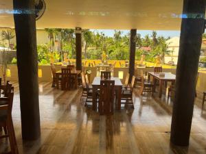 a restaurant with wooden tables and chairs and a patio at Cabilao Sunset Dive & Beach Resort in Loon