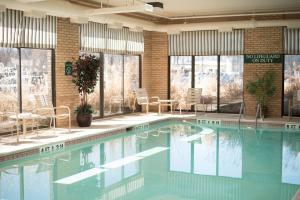 a swimming pool with chairs and tables in a building at Holiday Inn Express Easton by IHG in Easton