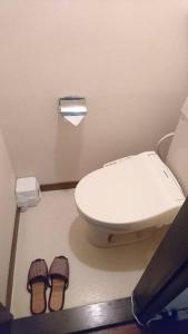 a bathroom with a toilet and a pair of slippers at アルピエa敷地内無料駐車場付き in Kumamoto
