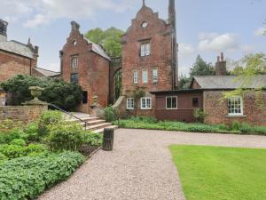 an old brick building with a staircase in front of it at South Tower Cottage in Macclesfield