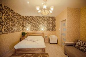 a bedroom with a bed and a chair and a chandelier at Molex Apartments 2 in Chernihiv