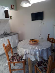 a kitchen with a table with chairs and a television at San Cayetano Departamento por dia con cochera gratis in Bahía Blanca