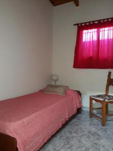 a bedroom with a bed and a red window at San Cayetano Departamento por dia con cochera gratis in Bahía Blanca