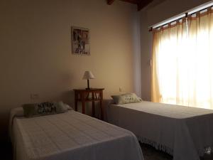 a bedroom with two beds and a window at San Cayetano Departamento por dia con cochera gratis in Bahía Blanca