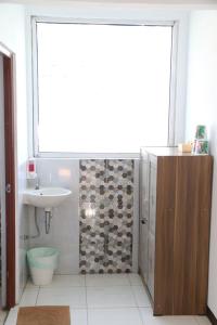 baño con lavabo y ducha con ventana en Mj's Guesthouse Dog Lovers en Lembang