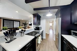 a kitchen with black cabinets and a white counter top at Hawaiian Paradise in Anaheim