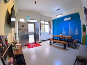 a living room with a table and a blue wall at 拼圖民宿 in Jinning