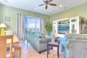 ein Wohnzimmer mit einem Sofa, Stühlen und einem TV in der Unterkunft Bayway Luxury Suites 1 townhouse in Clearwater Beach