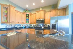 a kitchen with wooden cabinets and a stainless steel refrigerator at Bayway Luxury Suites 1 townhouse in Clearwater Beach