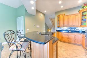 a kitchen with wooden cabinets and a black counter top at Bayway Luxury Suites 1 townhouse in Clearwater Beach