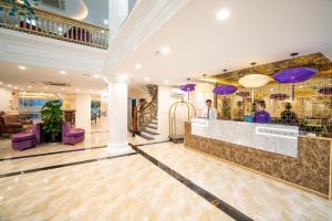 una hall con bar e sedie viola di Le Indochina Hotel & Beach Da Nang City a Da Nang