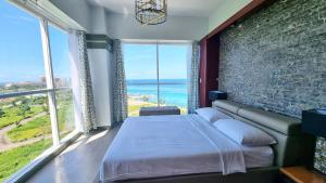a bedroom with a large bed and large windows at La Mirada Residences in Mactan +37 photos