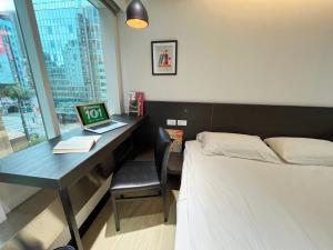 台北的住宿－福爾摩莎北驛旅館 ，一间卧室配有一张床和一张带笔记本电脑的书桌