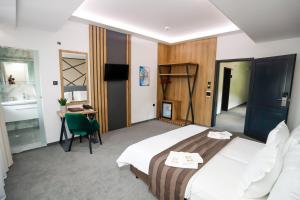 a hotel room with a bed and a desk and a sink at Glavatarski Han in Glavatartsi