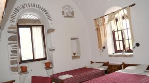 a room with two beds and two windows at Karampela Despina in Mestá +11 photos