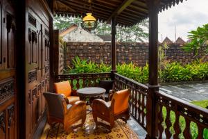 eine Veranda mit Stühlen und einem Tisch auf dem Balkon in der Unterkunft Bale Devata Resort in Sleman