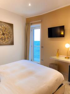 a bedroom with a large white bed and a window at La Ripa Camere Vernazza in Vernazza