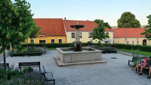 a fountain in a courtyard with people sitting on benches at Hotel Pod Stráží in Lhenice