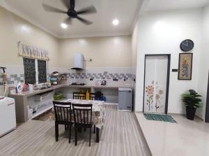 a kitchen with a table and chairs and a ceiling fan at Desa Hana Homestay in Kuala Terengganu