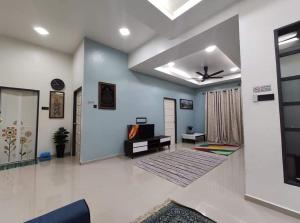 a living room with a ceiling fan and a couch at Desa Hana Homestay in Kuala Terengganu