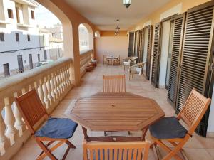 patio z drewnianym stołem i krzesłami na balkonie w obiekcie Sol 28 - Grupo Berna w miejscowości Colonia Sant Jordi