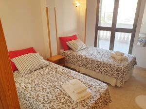 two beds in a small room with a window at Sol 28 in Colonia Sant Jordi