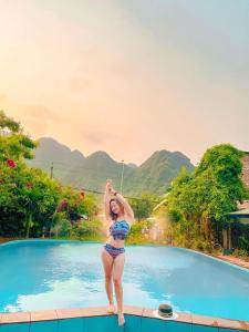 uma mulher à beira de uma piscina em Lucky Homes em Phong Nha