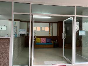 una puerta corredera de cristal con un sofá en una habitación en Baanpak Sam Anong, en Hua Hin