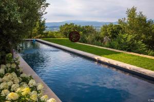 a swimming pool in the middle of a garden at Une Sieste en Luberon in Bonnieux
