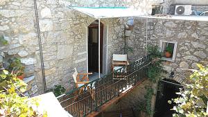a stone house with a balcony with a table and chairs at Karampela Despina in Mestá