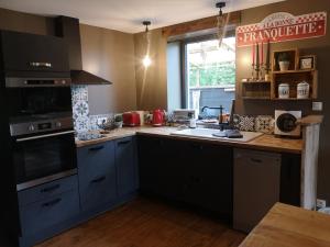 a kitchen with blue cabinets and a counter top at Gîte La Grange de La Trigalle avec spa professionnel privatif in Valognes