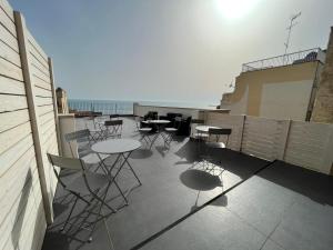 patio ze stołami i krzesłami na balkonie w obiekcie B&B DEA Gela w mieście Gela