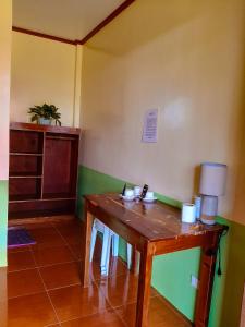 um quarto com uma mesa de madeira num quarto em Marianne's Guest House em New Agutaya