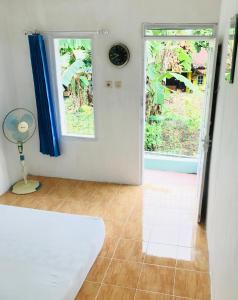 Zimmer mit einer Tür, einem Fenster und einem Ventilator in der Unterkunft TURU Homestay Syariah in Banjarnegara