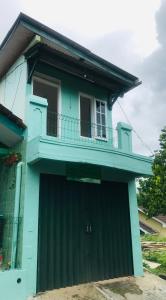 ein blaues Haus mit einem Tor und einem Balkon in der Unterkunft TURU Homestay Syariah in Banjarnegara