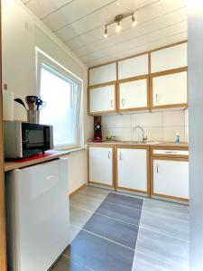 a kitchen with a refrigerator and a microwave at Schlafen wie Zuhause Monteur und Ferienwohnungen Rahden in Rahden