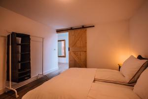 a bedroom with a bed and a sliding barn door at Prachtig gerenoveerd bakhuis EneRené in Vught