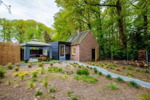 a small house in the woods with a garden at Prachtig gerenoveerd bakhuis EneRené in Vught
