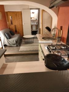 een keuken met een fornuis en een kamer met een bed bij Le Calme à la source in Bréchamps