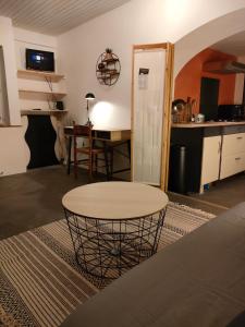 Il comprend un salon avec une table et une cuisine. dans l'établissement Le Calme à la source, à Bréchamps