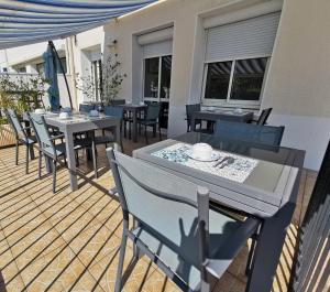 un patio con mesas y sillas en una terraza en Hotel le Pasteur, en Royan