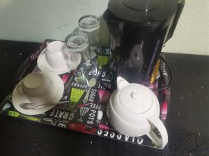 a tea pot and cups on a table at Sunset View Palace Guest House in Soshanguve