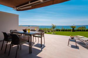 a patio with a table and chairs and a view of the ocean at Apartments Mandre in Mandre